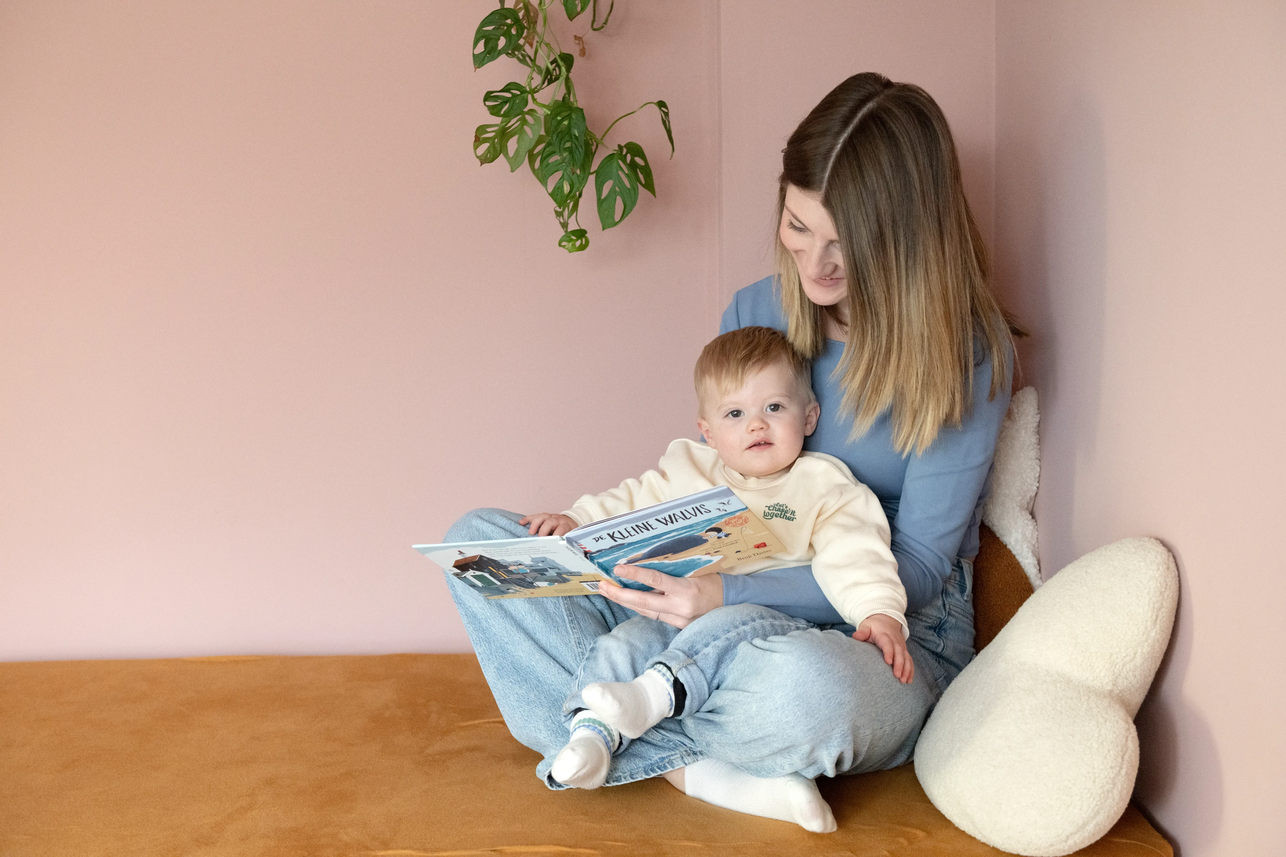 Vrouw met kind op schoot lezend in een boekje