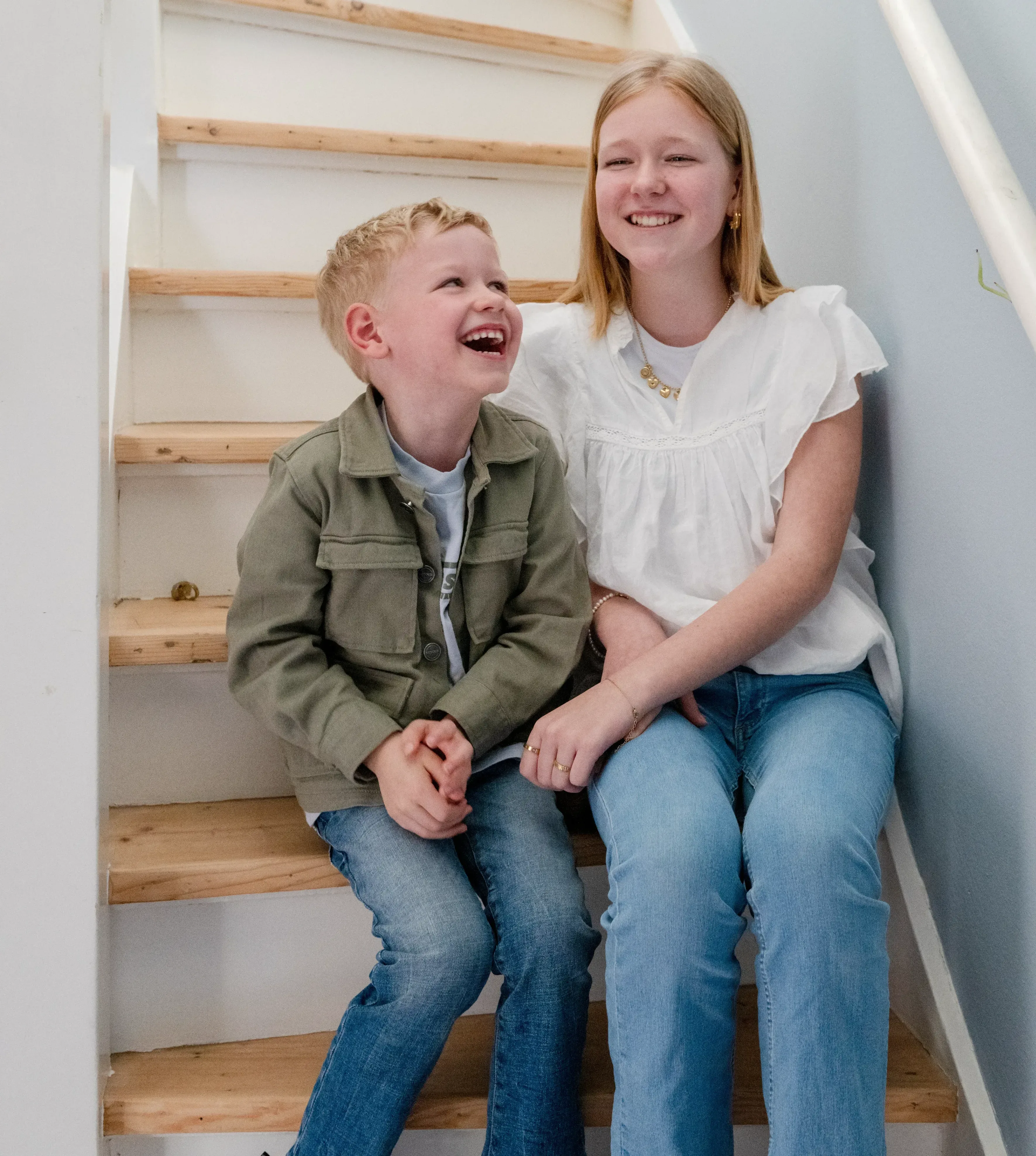 Twee kinderen zitten op trap en lachen