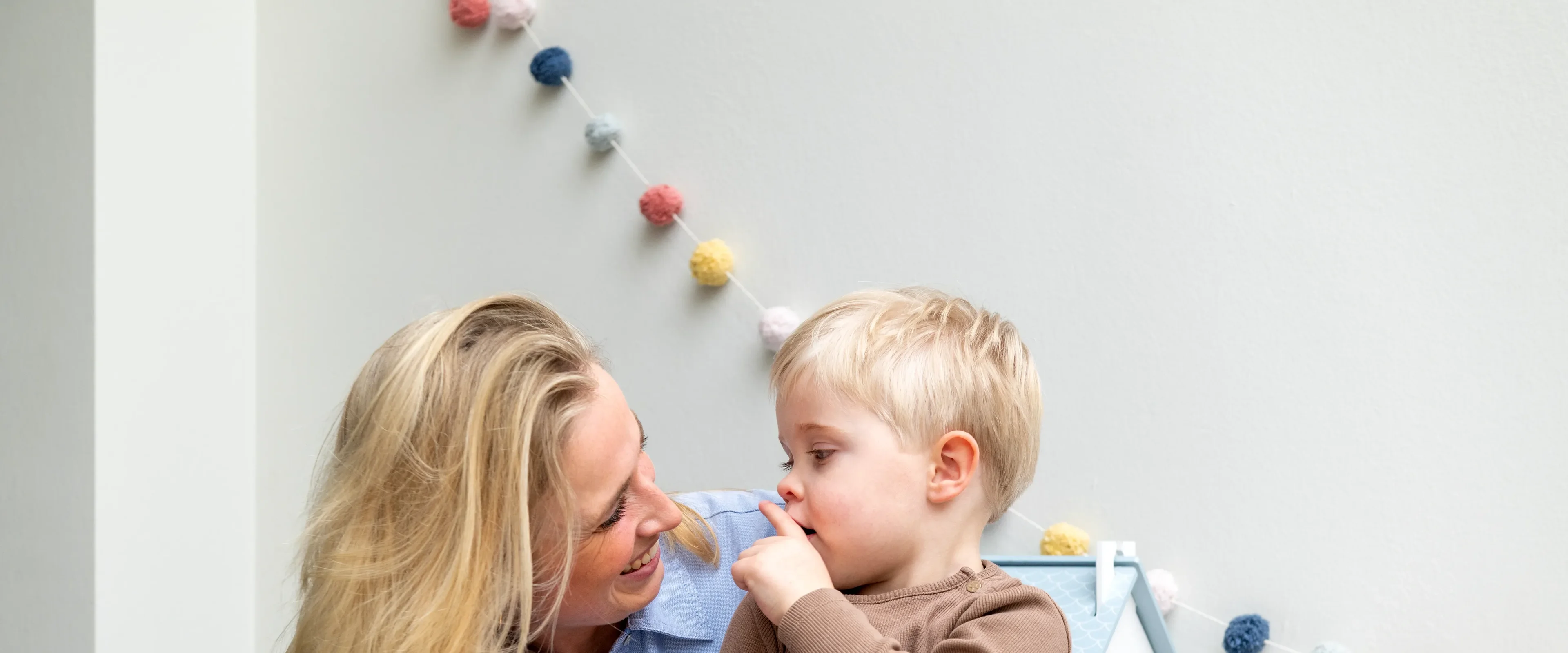 Vrouw heeft kind op schoot en lachen naar elkaar