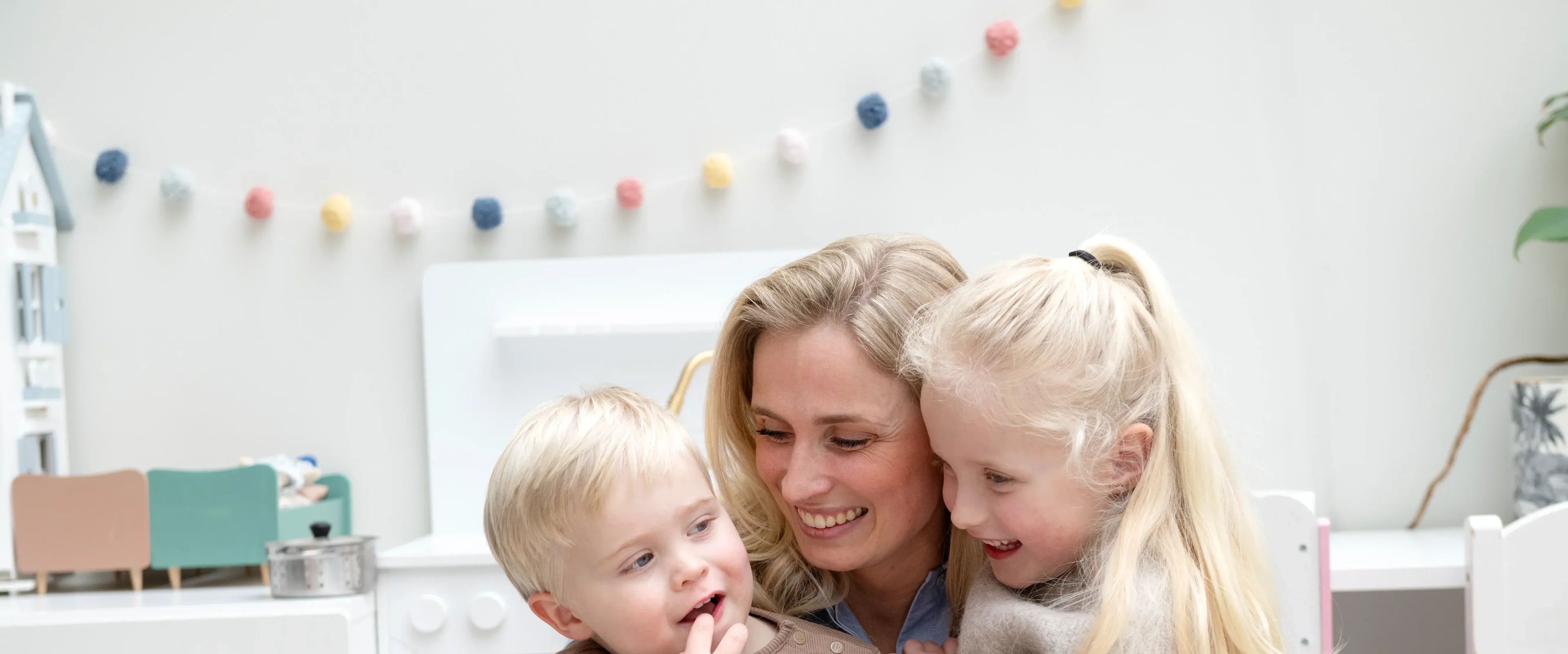 Vrouw met 2 kinderen in armen, lachen naar elkaar