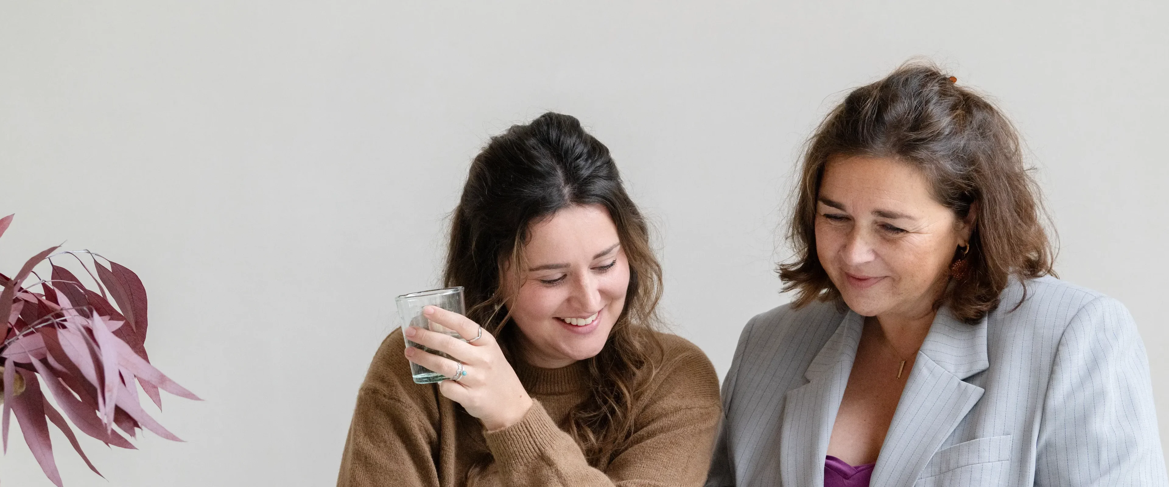Twee vrouwen lachen en kijken naar beneden