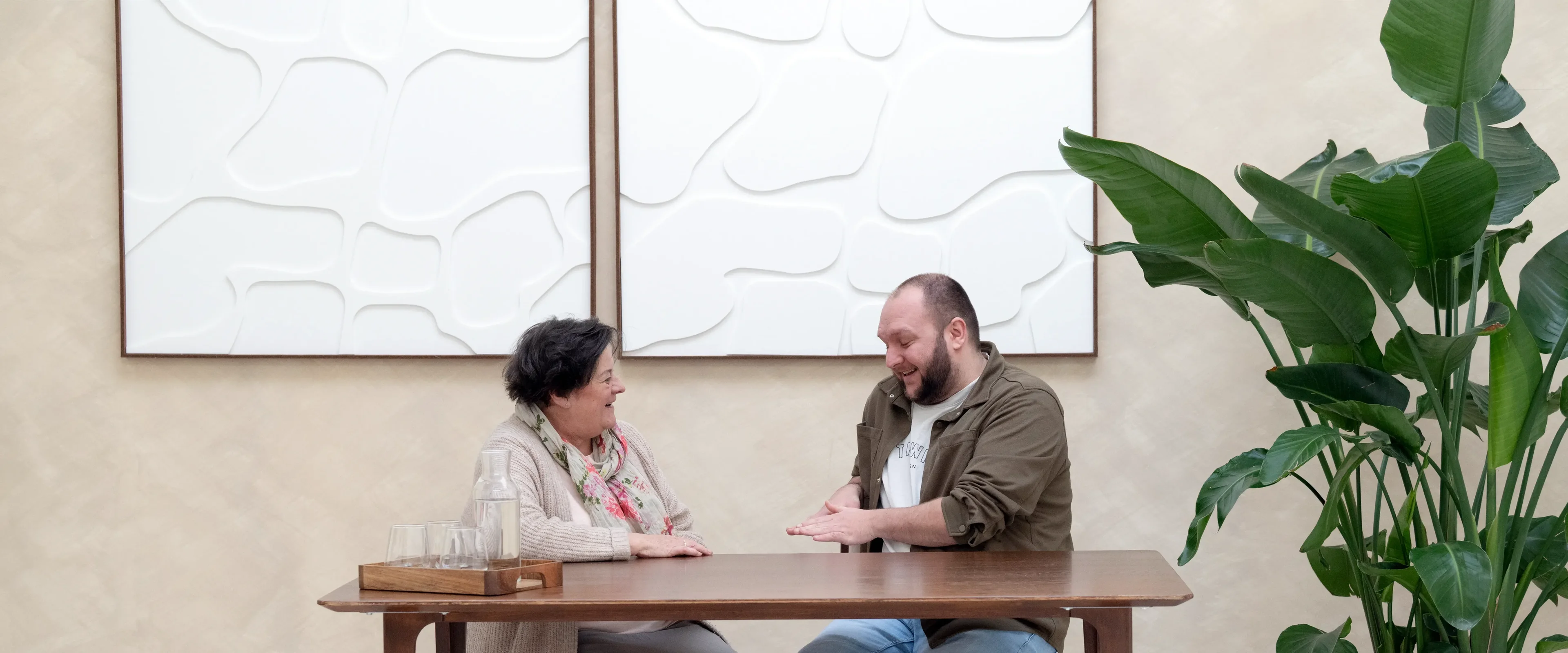 Man en vrouw zitten aan tafel naar elkaar te lachen