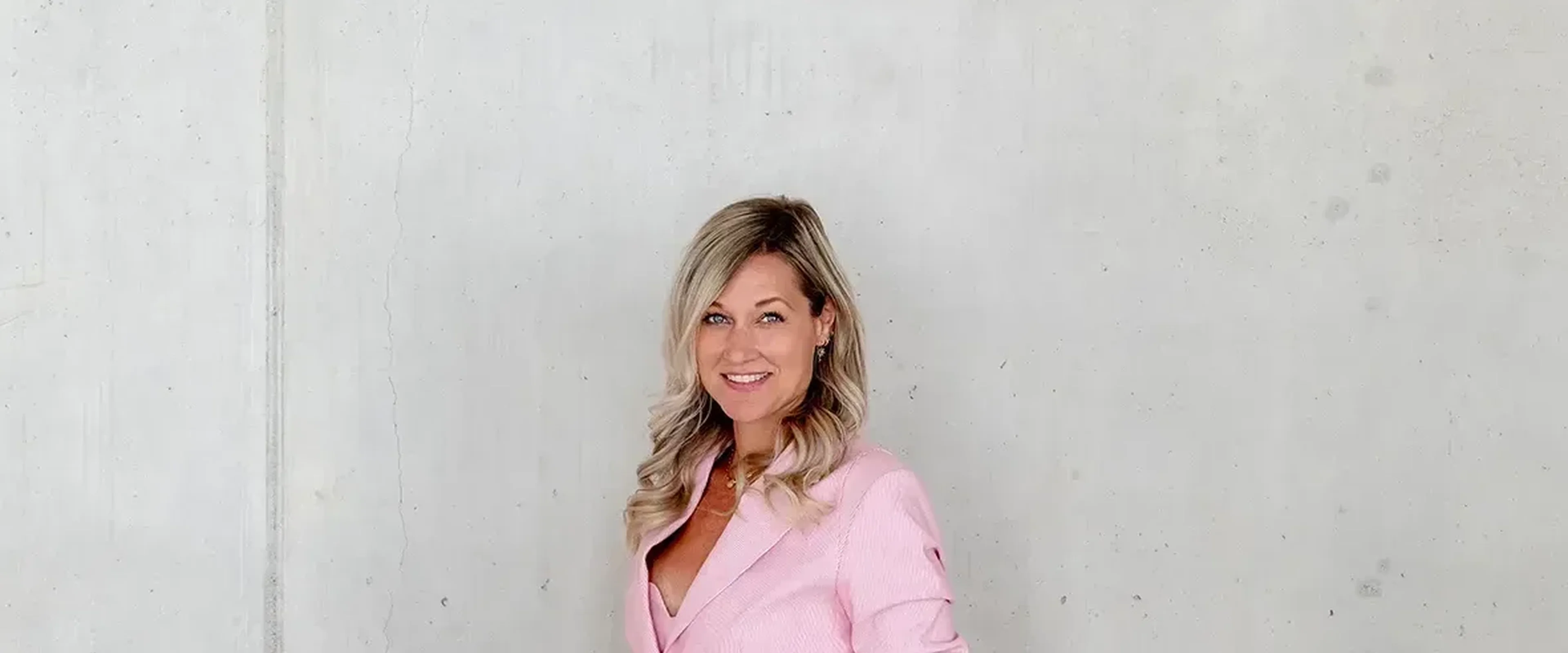 Vrouw staat en lacht naar de camera