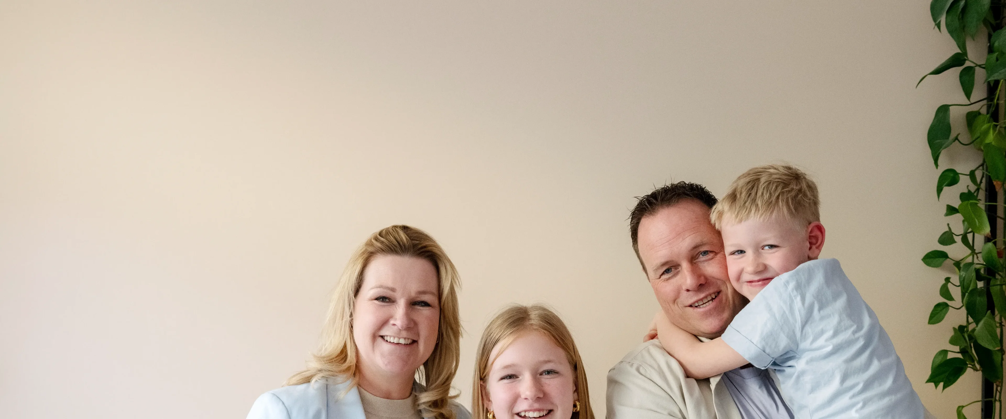 Gezin van man, vrouw, dochter en zoon lachend naar de camera